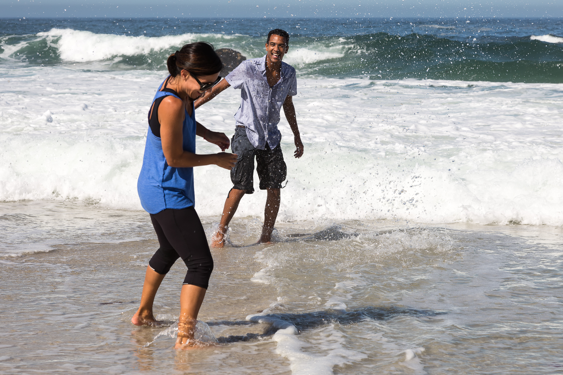 Young Couple Playing in the Water on the Beach