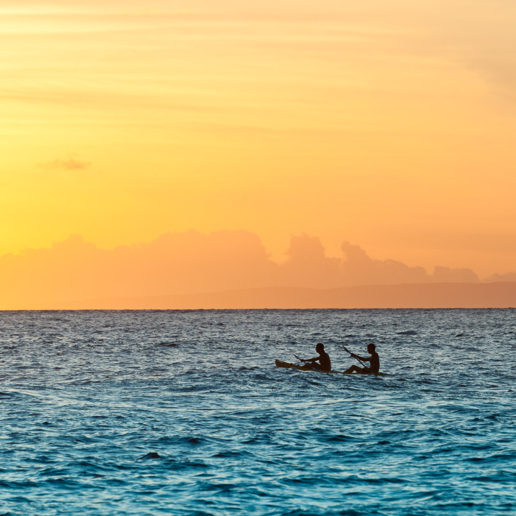 shooting silhouettes at sunset of two men in a boat