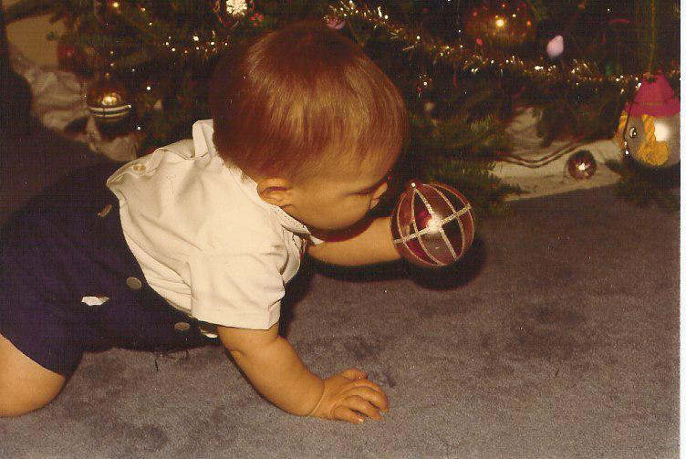 Little toddler boy looking at Christmas ornament