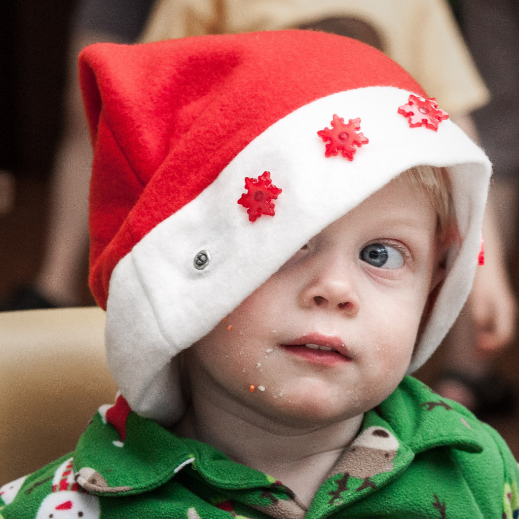 holiday photos of your family will include fun portraits like this one of a young boy with doughnut crumbs on his head and wearing a Santa hat