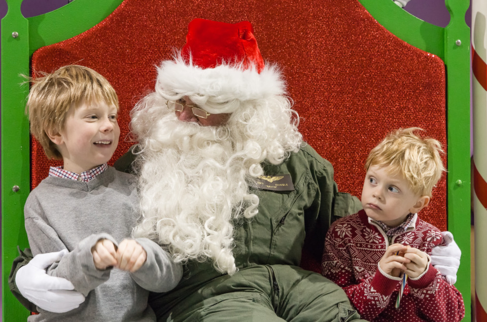 Two young boys meeting Santa in a flight suit
