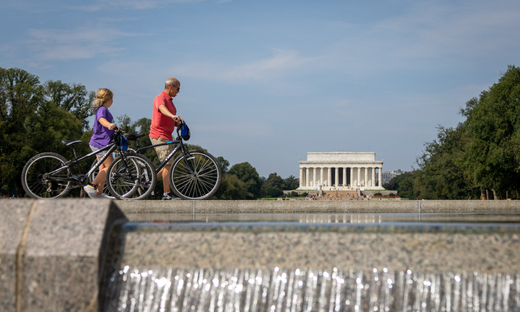 making travel photos unique by framing the Lincoln Memorial with a waterfall and bicycle riders