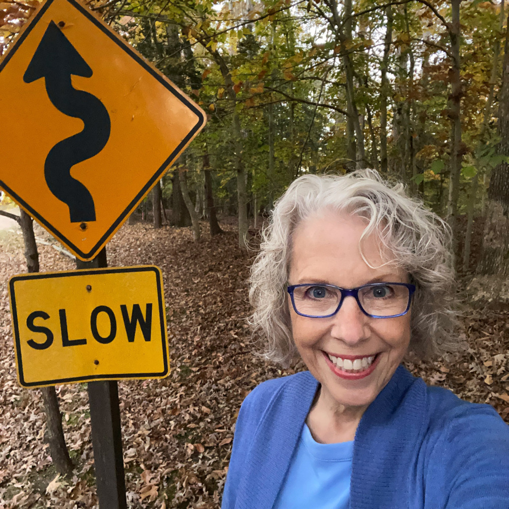 woman taking a selfie next to Slow sign