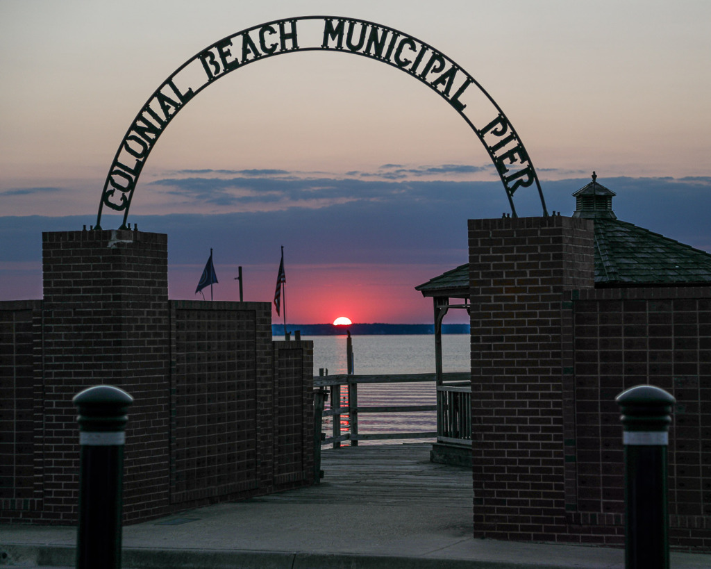 photo of sun rising behind the Colonial Beach Municipal Pier